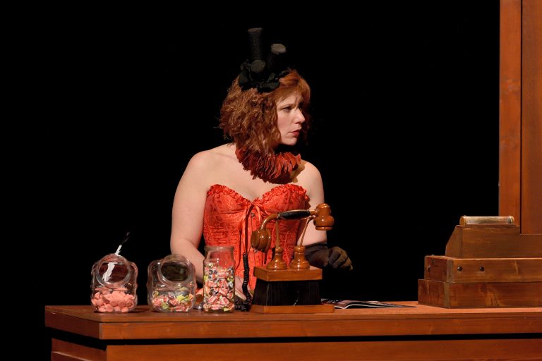 Image de la représentation "Le Magasin des Suicides" sur laquelle une actrice est présente seule, et semble observer une scène étonnante - une création de la compangie Nandi